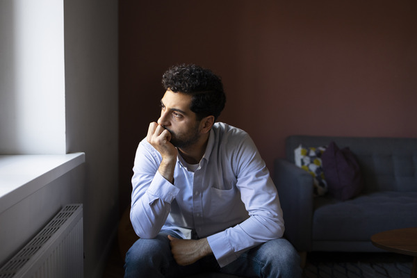 Man sitting indoors looking anxious Safemind Studio